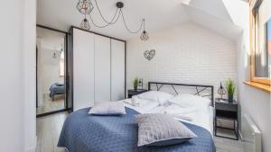 una camera da letto con letto blu e cuscini bianchi di Prywatne apartamenty w obiekcie Nautikka Resort, Sun & Snow a Krynica Morska