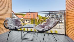 2 sedie e un tavolo sul balcone di Prywatne apartamenty w obiekcie Nautikka Resort, Sun & Snow a Krynica Morska