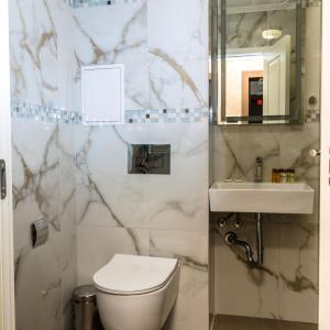 a bathroom with a toilet and a sink and a mirror at COOP Apartments, Sofia in Sofia