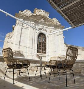 two chairs and a table in front of a building at Donna Nina in Monopoli