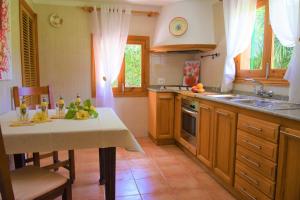 eine Küche mit einem Tisch, einer Spüle und einem Herd in der Unterkunft Madona - Es Puig in Búger