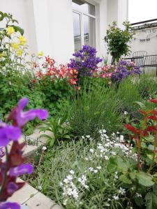 a garden with colorful flowers in front of a house at Veronika Home Tbilisi in Tbilisi City