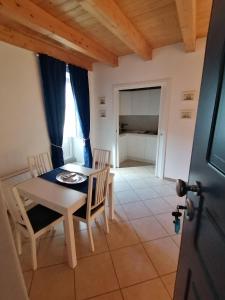 a kitchen and dining room with a table and chairs at Domus plano de laczarulo Acciaroli in Acciaroli +16 photos