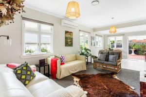 a living room with white furniture and windows at Spacious Family Retreat in City - Netflix - WiFi in Auckland