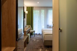 een hotelkamer met een slaapkamer en een bed bij Hotel garni Grundmühle in Bad Schandau