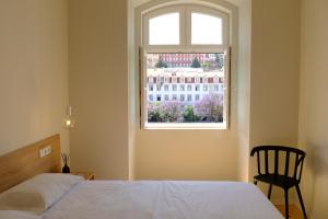 sypialnia z łóżkiem i oknem w obiekcie Liberator Rossio w Lizbonie