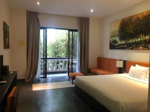 a hotel room with a bed and a balcony at Palm View Villa in Hoi An