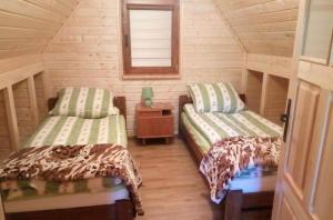 Habitación con 2 camas en una cabaña de madera en Domek u Freda en Posada Górna