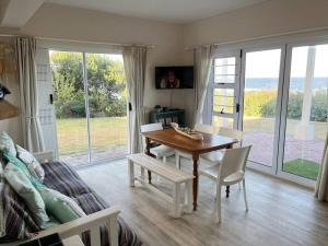 a living room with a table and chairs and a couch at SEEMEEU in Jeffreys Bay