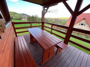 una terraza de madera con un banco en el porche en Domek u Freda en Posada Górna