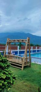 a wooden bench sitting next to a swimming pool at Poonsap Homestay in Nan