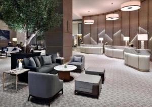 a hotel lobby with couches and chairs and a tree at Deluxe - Address Dubai Mall - The Residence in Dubai