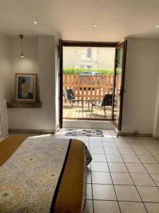 ein Schlafzimmer mit einem Bett und eine Terrasse mit einer Terrasse in der Unterkunft Gîte des Anciennes Salines Nationales in Montmorot