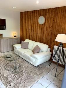 ein Wohnzimmer mit einem weißen Sofa und einem Tisch in der Unterkunft Gîte des Anciennes Salines Nationales in Montmorot