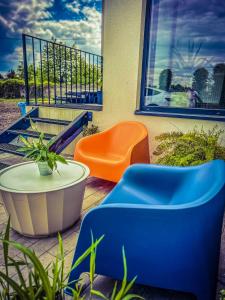 uma cadeira laranja e azul sentada numa varanda em Apartamenty Gliwice Staromiejska 65 em Gliwice