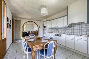 une cuisine avec une table en bois et des chaises bleues dans l'établissement Villa Playa, à Veyrier-du-Lac