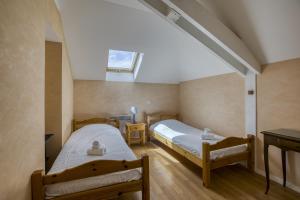 two twin beds in a room with a skylight at Villa Playa in Veyrier-du-Lac