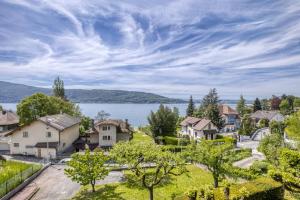 een dorp met een meer op de achtergrond bij Villa Playa in Veyrier-du-Lac