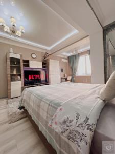 a master bedroom with a bed and a tv at RentHouse Apartments Elegant in Chişinău