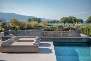 a house with a swimming pool next to a swimming pool at Fivi Luxury Villa, with Heated Pool & SeaViews, By ThinkVilla in Tavronitis
