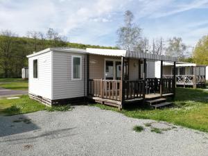 een tiny house met een veranda en een terras bij Camping Les Ballastières - Vosges du Sud in Champagney