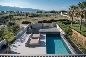 a swimming pool with two loungers and a swimming poolvisor at Fivi Luxury Villa, with Heated Pool & SeaViews, By ThinkVilla in Tavronitis