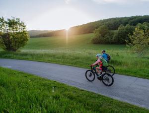 a man and a woman riding bikes down a road at San Giovanni Terme Rapolano in Rapolano Terme