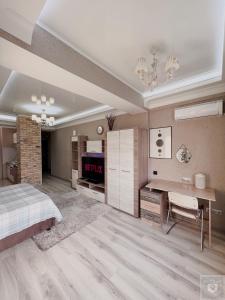sypialnia z łóżkiem, biurkiem i telewizorem w obiekcie RentHouse Apartments Elegant w Kiszyniowie