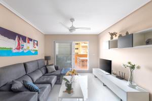 ein Wohnzimmer mit einem Sofa und einem TV in der Unterkunft Lopimar Exclusivo in Canet d'en Berenguer