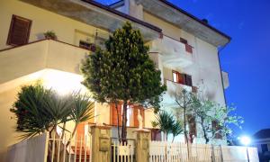 a building with a tree in front of it at B&B Mattia in Civitanova Marche