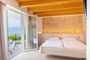 サン・ゼーノ・ディ・モンターニャにあるHotel Lagunaのベッドルーム(ベッド1台付)、バルコニーが備わります。