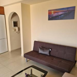 a living room with a couch and a table at vaccation appartement in Káto Almirí