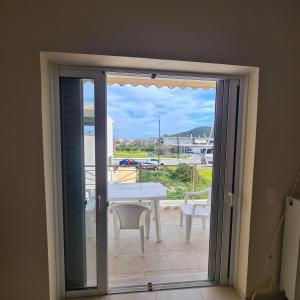 a sliding glass door leading to a balcony with a table at vaccation appartement in Káto Almirí