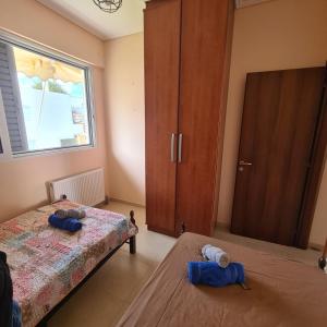 a bedroom with two beds and a large window at vaccation appartement in Káto Almirí