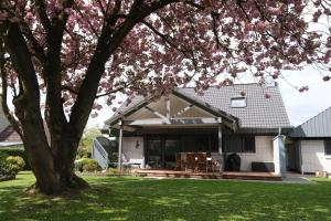 una casa con terraza y un árbol en Casa alla Torre, en Vollersode