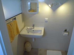 a white bathroom with a sink and a mirror at Brela SP small loft-no parking in Brela