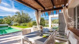 a table and chairs on a patio with a swimming pool at Molino del Azahar El Valle by Ruralidays in Melegis
