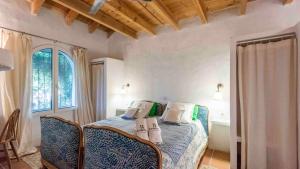 a bedroom with a bed with chairs and a window at Molino del Azahar El Valle by Ruralidays in Melegis +41 photos