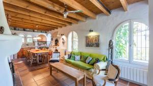 a living room with a green couch and a kitchen at Molino del Azahar El Valle by Ruralidays in Melegis