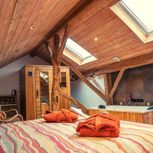 a bedroom with a large bed with wooden ceilings at Les Monts d'Aisne in Mormont