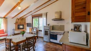 a kitchen with a table and a dining room at Cortijo la Era Castril by Ruralidays in Castril