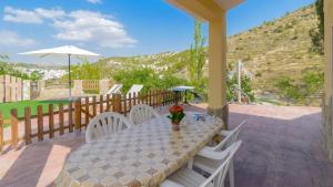 a table and chairs on a patio with a view of a hill at Cortijo la Era Castril by Ruralidays in Castril
