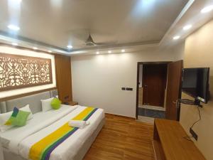 a bedroom with a large bed and a television at Hotel Shaurya Inn in Lucknow