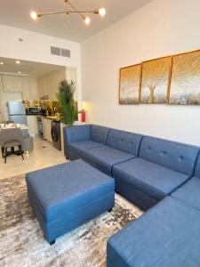 a living room with a blue couch and a kitchen at Downtown Dubai 7 minutes away from Burj Khalifa in Dubai