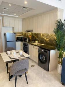 a kitchen with a table and a stove and a dishwasher at Downtown Dubai 7 minutes away from Burj Khalifa in Dubai