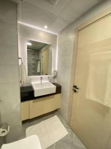 a white bathroom with a sink and a mirror at Downtown Dubai 7 minutes away from Burj Khalifa in Dubai
