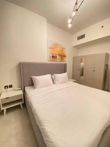 sypialnia z dużym białym łóżkiem w pokoju w obiekcie Downtown Dubai 7 minutes away from Burj Khalifa w Dubaju