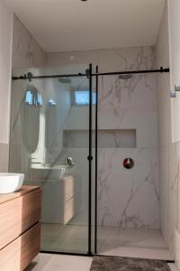 y baño con ducha y puerta de cristal. en Luxury House Buena vista en Ica