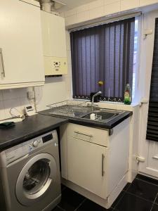 a kitchen with a sink and a washing machine at Stylish Modern 2 Bed House, St Helens in Saint Helens