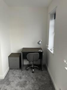 an office with a desk with a chair and a lamp at Stylish Modern 2 Bed House, St Helens in Saint Helens